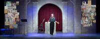 a woman is standing in front of a stage with pictures on it